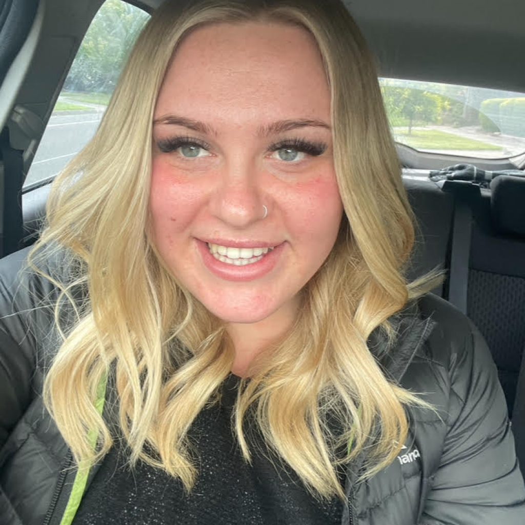 Photo of a woman with blonde hair sitting in a car.